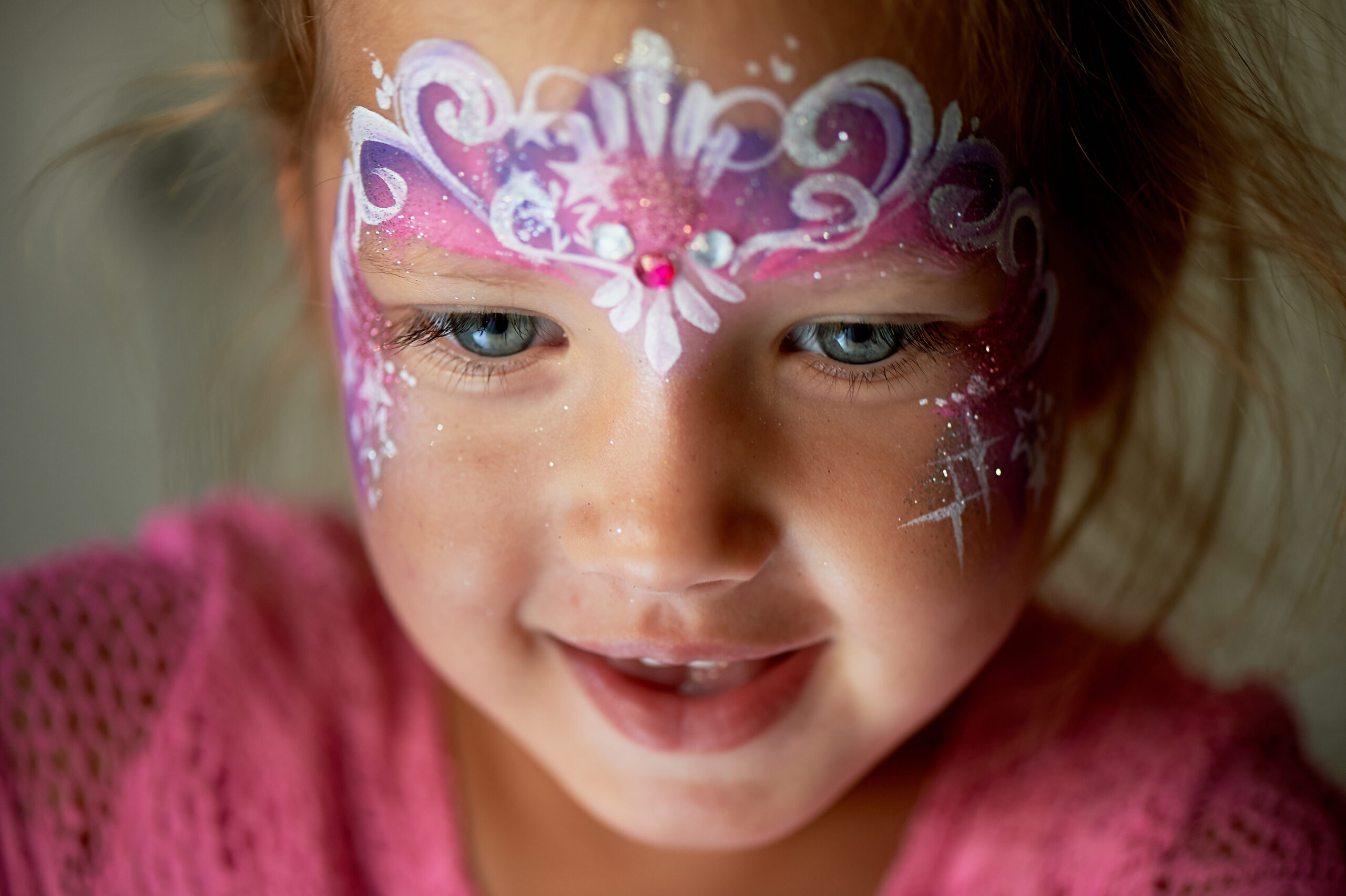pretty exciting blue eyed girl of 2 years with a face painting
